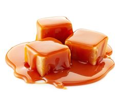 three pieces of caramel jello sitting on top of each other with syrup pouring over them