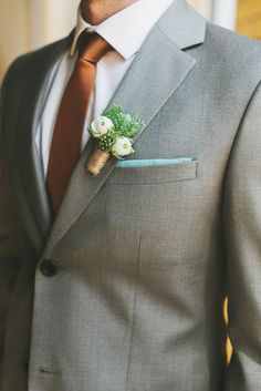 a man in a suit and tie with a boutonniere on his lapel