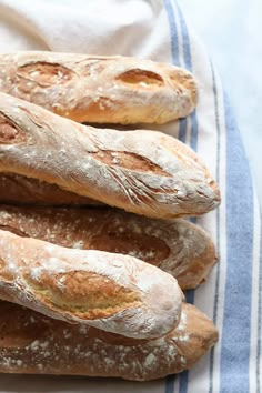 three loaves of bread sitting on top of a blue and white towel