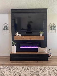 a living room with a fireplace and tv on the wall in front of an entertainment center