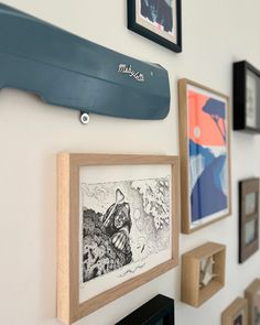 there are many framed pictures on the wall and one is holding a surfboard above it