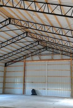 the inside of a large building with metal roofing and walls that have been painted white