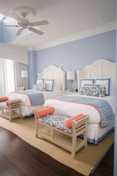 two beds in a bedroom with blue and white decor