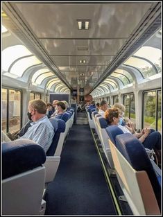 people sitting in seats on a train looking out the windows