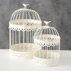 two white birdcages sitting next to each other