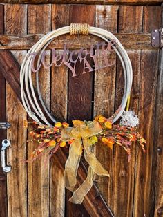 a wreath with the word welcome hanging from it's side on a wooden door