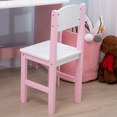 a pink wooden chair next to a teddy bear