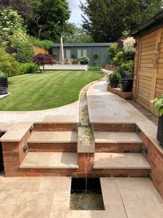 a garden with steps leading up to a water feature