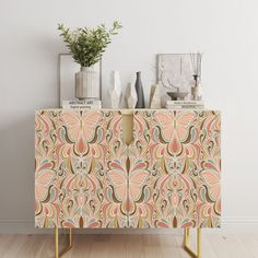 a sideboard with an ornate design on it and vases sitting on top of it