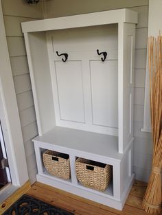 a white bench with two baskets underneath it