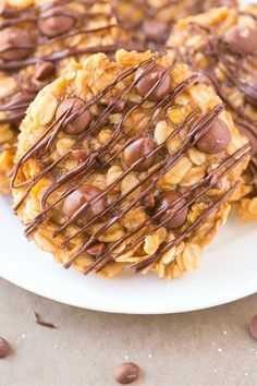 chocolate drizzled on top of cookies on a white plate with chocolate chips