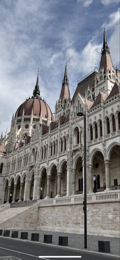 a large building with many towers on it's sides and a street light in front of it