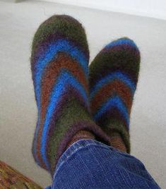 a person with their feet up on a couch wearing striped socks and blue denim jeans