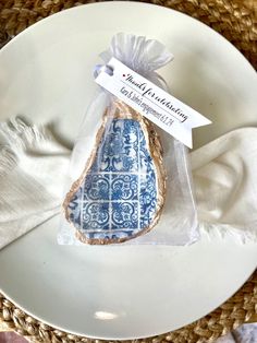 a white plate topped with a blue and white egg shaped cookie next to a napkin