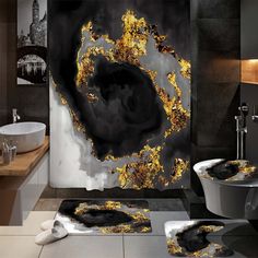 a black and white bathroom with gold leafy designs on the shower curtain, toilet seat covers and rugs