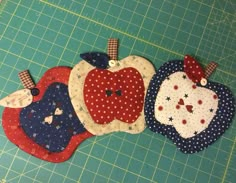 three pieces of fabric are laid out on a cutting board to make an apple applique