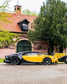 two black and yellow sports cars parked in front of a building