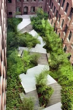 an aerial view of a building with stairs leading up to the top and trees growing on the ground