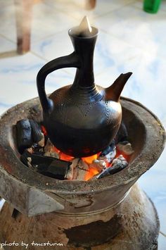 a tea pot sitting on top of a fire pit