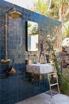 a blue tiled bathroom with a sink and ladder