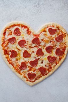 a heart shaped pizza sitting on top of a table