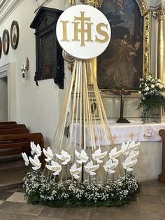 a church alter with flowers in the center and an ihs sign on it's side