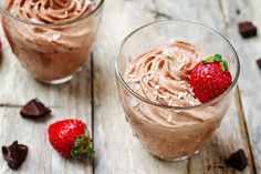 two desserts with chocolate frosting and strawberries are on the table next to each other