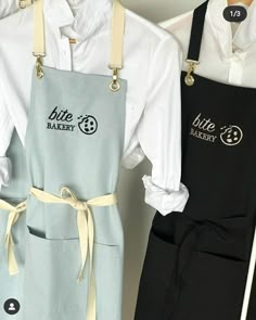 two aprons are hanging on the wall next to each other