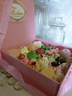 a pink box filled with lots of different types of candies next to a glass jar