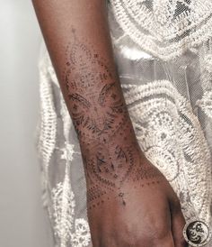 a woman's arm with an intricate tattoo design on the left side of her arm