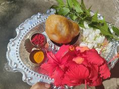 a person holding a plate with flowers and powdered food on it's side