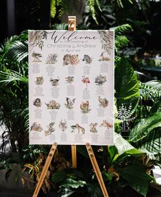 a welcome sign sitting on top of a wooden easel in front of some plants