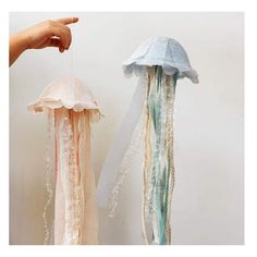 there are two jellyfishs hanging on the wall and one is being held up