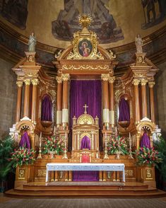 an ornate alter in a church with purple curtains