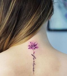 a woman's back neck with a flower tattoo on it