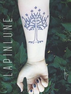 a woman's arm with a tree tattoo on it