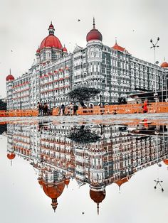 a large building with red domes on it's top and reflection in the water