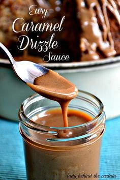 a spoon full of caramel drizzle sauce on top of a plate with chocolate cake in the background