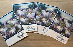 four cards with flowers on them sitting on a table