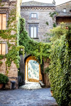 an old building with ivy growing on it's walls and door leading into the courtyard