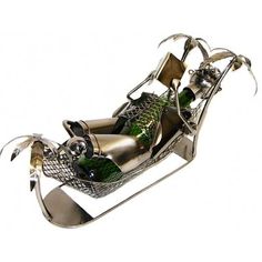 a metal sleigh filled with bottles of wine and silverware on a white background