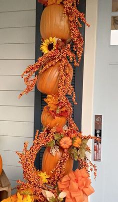 a porch decorated with pumpkins and flowers