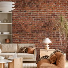 a living room filled with furniture and a brick wall behind the couches is a coffee table