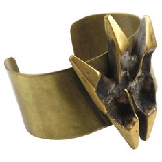 This impressive sculptural brutalist bronze cuff bracelet was designed by French sculptor and painter Henri Nogaret (1927 -). The large brass band is topped with a Mid-Century modernist abstract ornamental sculpture made of gilded bronze. The signature is engraved on the side. Please check our storefront, as we have the matching pendant necklace available. Measurements: circumference is 6.69 in (17 cm) - Opening is 1.25 in (3.2 cm) - Band width is 1.19 in (3 cm) - Sculpture element is 1.69 in wide (4.2 cm) x 2.32 in high (5.8 cm) - Fit a Medium size wrist with an average 6.50 in circumference (16.5 cm). Feel free to double-check the measurements and ask any questions you have before making your purchase. This item is a final sale. No returns will be accepted for an unfit size. Bronze Cuff Bracelet, French Sculptor, Dagger Earrings, Mommy Jewelry, Jewelry Staples, Silver Ring Designs, Antique Bracelets, Enamel Bangle, Bold Jewelry