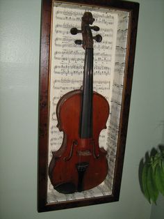 an old violin is hanging on the wall