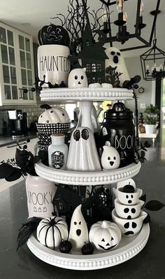 a three tiered halloween cake decorated with black and white pumpkins, jack - o'- lanternes, ghost faces and more