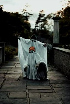 a person in a ghost costume on a brick walkway