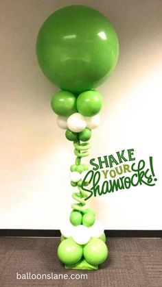 green and white balloons in the shape of a tree with words shake your shamrock on it