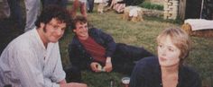 three people sitting on the grass with beer