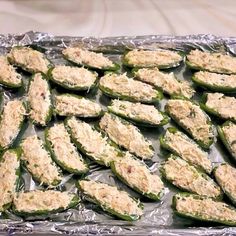 an aluminum pan filled with green peppers covered in chicken and cheese toppings on top of tin foil